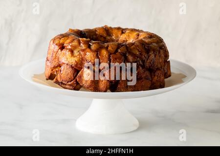 Pomme cannelle retirer le gâteau sur un socle, sur un fond léger. Banque D'Images