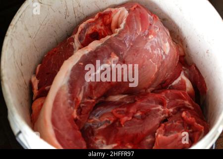 Effet de flou artistique sur la texture ou le fond de savoureuses viandes fraîches de gros porc.Texture gros plan de la viande de bœuf rouge.Viande de fond.Seau blanc.Hors foyer Banque D'Images