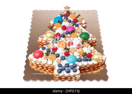 Gâteau festif du nouvel an et de Noël en forme d'arbre de Noël et décoré de baies et de bonbons.Poser à plat sur un fond blanc. Banque D'Images