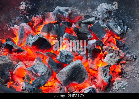 des émonteurs de bois qui brûlent avec de la chaleur rouge et des cendres grises dans un bol en métal pour barbecue Banque D'Images