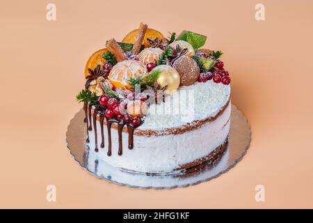 Fruit de Noël décoré de gâteau au chocolat blanc fait maison et de décorations pour le nouvel an.Sur fond jaune. Banque D'Images