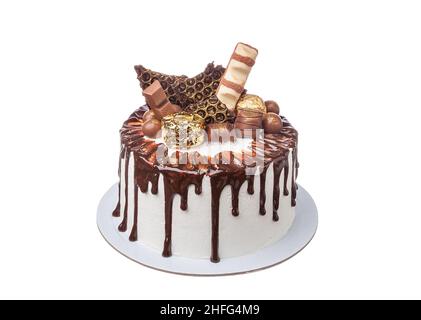 Gâteau blanc au chocolat à la décoration colorée avec bonbons et beignets.Gros plan sur fond blanc Banque D'Images