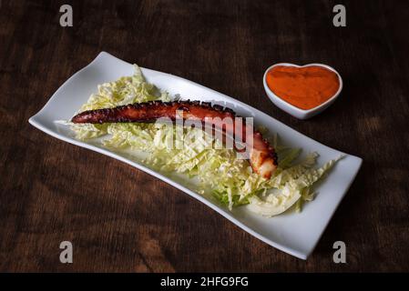 Sur un lit de chou, sur une assiette de pierre, accompagné de sauce mojo picon. Banque D'Images