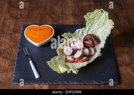 Sur un lit de chou, sur une assiette de pierre, accompagné de sauce mojo picon. Banque D'Images