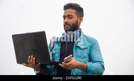 Jeune homme avec ordinateur portable et casque Banque D'Images