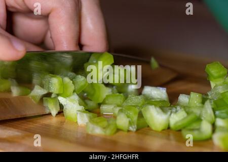 Couper du poivre vert frais sur une planche en bois, gros plan Banque D'Images