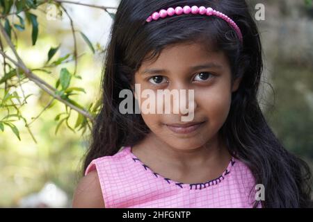 Une jolie fille regardant dans l'appareil photo - concept d'éducation de fille Banque D'Images