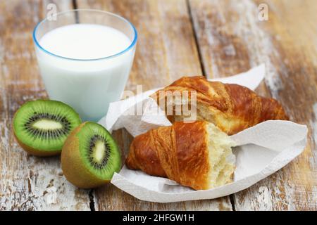 Petit déjeuner continental : croissant français, kiwi et verre de lait Banque D'Images