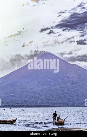 Volcan Momotombo avec des oiseaux de rivage et un pêcheur au premier plan, plusieurs jours après que le volcan est devenu actif après la dernière activité au début de 20t Banque D'Images