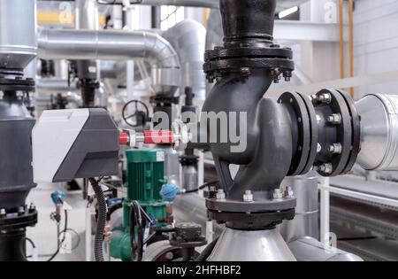 Vanne à bride à trois voies avec entraînement électrique dans une salle de chaudière à gaz. Banque D'Images