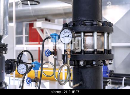 Clapet anti-retour à bride avec manomètre dans une salle de chaudière à gaz. Banque D'Images