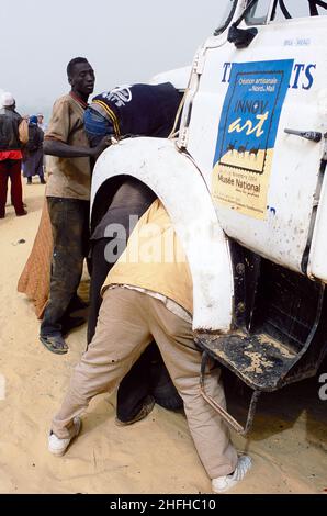 Afrique de l'Ouest, Mali, Sahara.La route de Tombouctou.En attendant le ferry pour traverser le Niger.Une chance de faire de l'entretien sur un camion en direction du Festival dans le désert à Essakane en 2005. Banque D'Images