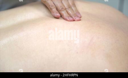 Gros plan pour les mains de physiothérapeute faisant un massage du dos au patient allongé, soins de santé, concept de relaxation.Mains huileuses d'un masseur appuyant sur le dos spécial Banque D'Images