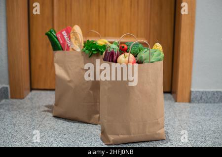 Des sacs de shopping de nourriture sont à la porte de la maison ou de l'appartement.Livraison de légumes et de fruits pendant la quarantaine et l'auto-isolement. Banque D'Images