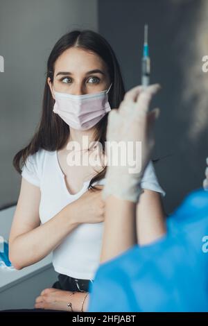 Le patient avait peur du vaccin tenu par la main du médecin.Vaccination contre le coronavirus.Équipement de laboratoire, seringue.Traitement médical.Médecin Banque D'Images