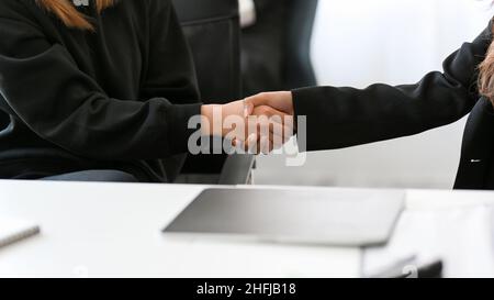 Les femmes d'affaires se secouent la main au bureau.Partenaires commerciaux, relations commerciales, concepts de coopération, image de gros plan Félicitations. Banque D'Images