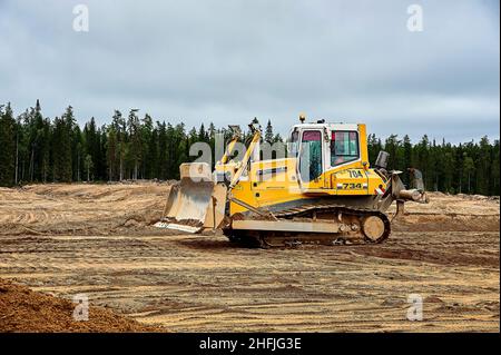 Un tracteur de bulldozer jaune se trouve dans une fosse de sable Banque D'Images