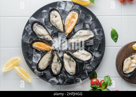 attention sélective. moules crues dans l'évier, étalées sur glace sur une assiette. une spécialité chère. service de restaurant Banque D'Images