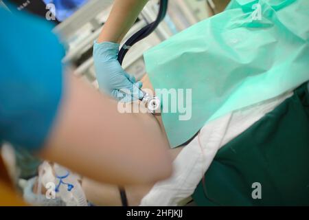 Le médecin écoute la respiration du patient avec le stéthoscope pendant l'aide d'urgence dans le RE. Banque D'Images