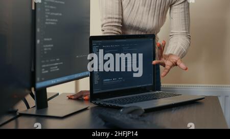 Gros plan de l'ordinateur portable exécutant l'algorithme d'analyse du code sur le bureau devant les programmeurs faisant le travail d'équipe sur le projet de groupe.Ordinateur portable compilant la base de données dans le bureau de développement de logiciels. Banque D'Images