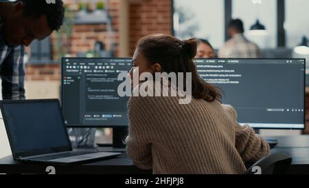 Programme logiciel mettant l'ordinateur portable avec code source sur le bureau de codeur de collègue demandant l'opinion sur la base de données.L'algorithme d'écriture du développeur est interrompu par un collègue qui souhaite obtenir de l'aide pour corriger les erreurs. Banque D'Images