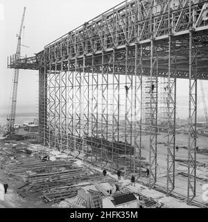 Aéroport de Heathrow, BEA Servicing Hangar, Heathrow, Hillingdon, Londres,12/01/1971.Le mur ouest de l'avion BEA desservant le hangar de l'aéroport d'Heathrow pendant sa construction, avec des hommes fixant des supports aux poutres au centre du mur.En octobre 1969, Laing a annoncé que sa succursale de génie industriel avait obtenu un contrat pour la construction d'un avion desservant le hangar de British European Airways à l'aéroport d'Heathrow.Il s'agissait x2019 du deuxième contrat majeur de l'entreprise à Heathrow, après l'achèvement du terminal de fret BEA et BOAC.Le hangar a été conçu pour un Banque D'Images