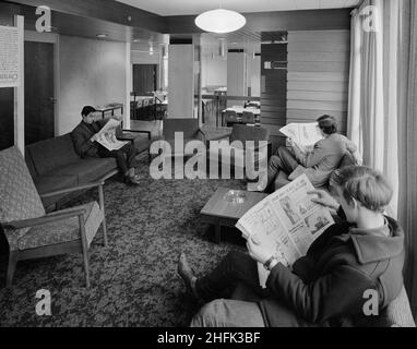 Parson's Field House, Université de Durham, Durham, comté de Durham, 08/12/1965.Trois hommes lisent des journaux dans la salle commune des étudiants des salles de résidence Parson's Field House de l'Université de Durham.Les salles de résidence de Parson Field House ont été conçues par les architectes Bernard Taylor and Associates et ont été construites par la région nord de la société de construction de Laing.Trois blocs de quatre étages ont été construits en utilisant des unités de béton préfabriquées de Laingwall, y compris le bloc un qui contenait la salle à manger principale et les salles communes au rez-de-chaussée avec des chambres d'étude aux étages supérieurs, b Banque D'Images