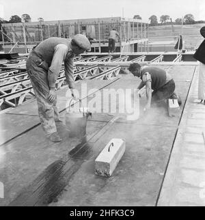 County High School, Gedling Road, Arnold, Gedling, Notinghamshire,12/09/1958.Deux travailleurs répandant du goudron chaud pour sceller les joints entre les panneaux de toit pendant la construction de l'école secondaire du comté d'Arnold.Les travaux ont commencé sur le site en mars 1958 et les travaux de construction ont été achevés pour la nouvelle période scolaire en septembre 1959.« Laingspan » était un système modulaire flexible de construction de châssis utilisant des unités préfabriquées en béton précontraint.Laing a développé le système en collaboration avec la Direction des architectes et des bâtiments du ministère de l'éducation et ingénieur-conseil AJ Harris.L'école Arnold était la première Banque D'Images