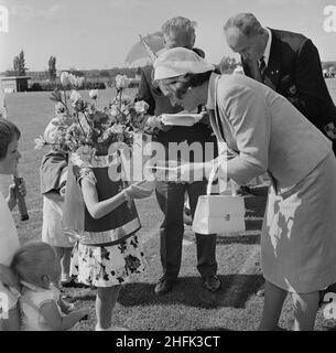 Laing Sports Ground, Rowley Lane, Elstree, Barnett, Londres,26/06/1965.Hilda Laing lors de la journée annuelle des sports de Laing, présentant un prix de concours de tenues de fantaisie à un jeune enfant habillé comme un vase de fleurs.En 1965, la journée sportive annuelle de Laing a eu lieu sur le terrain de sports de Rowley Lane le 26th juin.En plus du football et de l'athlétisme, il y a eu des événements de nouveauté, notamment la course de sacs et le Donkey Derby, et des événements pour les enfants, y compris des courses de karting, des compétitions de tenues de fantaisie et des manèges à poney. Banque D'Images