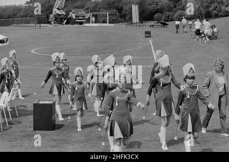 Laing Sports Ground, Rowley Lane, Elstree, Barnett, Londres,30/06/1984.Une troupe de drum majorettes s'éloignent du terrain de football après leur représentation pour le Gala Day au Laing's Elstree Sports Club. Banque D'Images