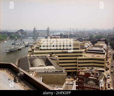 London Bridge City, Southwark, Greater London Authority, 19/06/1986.Vue vers l'est sur le complexe London Bridge City, montrant le HMS Belfast amarré sur la Tamise avec Tower Bridge au-delà.Divers bâtiments de ce complexe de bureaux, d'appartements et de boutiques sur la rue Tooley à London Bridge City ont été construits par Laing Management Contracting pour le groupe St Martins qui a redéveloppé l'ancien site Hay's Wharf sur la rive sud de la Tamise.Le réaménagement du site s'est déroulé sur 2 1/2 ans entre 1985-1988 et comprenait le pont no 1 de London, Cottons, Hays Galleria et 29-33 Banque D'Images