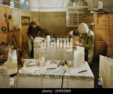 Buttercross, High Street, Ludlow, Shropshire, 21/05/1985.Deux pierres sculptent des blocs de pierre de remplacement pendant les travaux de rénovation au Buttercross.Les travaux de rénovation du Buttercross ont été effectués par la maçonnerie de pierres de Laing, et les travaux ont commencé en août 1984.Le bâtiment classé de catégorie I, qui a été construit à l'origine en 1743-46, a été restauré en utilisant le grès local de Grinshill de Shropshire.Les architectes de la rénovation étaient Catterall, Morris & amp; Jaboor de Shrewsbury.Cette photographie a été publiée en juin 1986 dans la lettre d'information mensuelle de Laing 'Team Spirit'. Banque D'Images