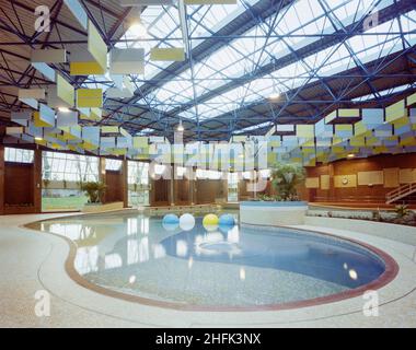 Centre de loisirs Kingfisher, Fairfield Road, Kingston upon Thames, Londres, 30/11/1983.La plage et les zones de lagune de la piscine du centre de loisirs Kingfisher, avec les panneaux insonorisants suspendus de la structure du toit.En avril 1982, une cérémonie de tonte du gazon a marqué le début symbolique de la construction d'une nouvelle piscine de loisir, de courts de squash et d'une cafétéria sur Fairfield Road pour le Royal Borough of Kingston upon Thames.La conception du schéma et le mémoire détaillé avaient été fournis par l'arrondissement en décembre 1981.Le hall de la piscine principale a été conçu pour se rapprocher d'un extérieur Banque D'Images