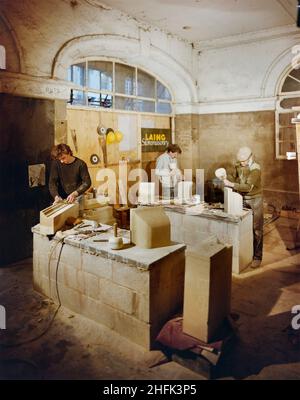 Buttercross, High Street, Ludlow, Shropshire, 21/05/1985.Trois pierres sculptent des blocs de pierre de remplacement pendant les travaux de rénovation au Buttercross.Les travaux de rénovation du Buttercross ont été effectués par la maçonnerie de pierres de Laing, et les travaux ont commencé en août 1984.Le bâtiment classé de catégorie I, qui a été construit à l'origine en 1743-46, a été restauré en utilisant le grès local de Grinshill de Shropshire.Les architectes de la rénovation étaient Catterall, Morris & amp; Jaboor de Shrewsbury.Cette photographie a été publiée en juin 1986 dans la lettre d'information mensuelle de Laing 'Team Spirit'. Banque D'Images