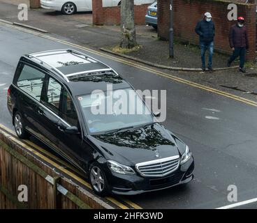 Un corbillard qui longe une rue pendant le confinement de Covid-19, avec deux hommes portant des masques protecteurs qui marchent le long du trottoir de l'autre côté de la route.La collection de lockdown pour la culture des cultures a été créée en avril et en mai 2020, en réponse à la pandémie de Covid-19.Pendant sept jours, le public a été invité à soumettre des photographies qui, selon lui, représentaient le mieux leur expérience de confinement en Angleterre, et à partir de ces soumissions, une centaine représentant toutes les différentes régions géographiques ont été choisies pour être archivées dans le quartier historique de l'Angleterre.À côté de ces images, dix artistes ont été très prometteurs Banque D'Images
