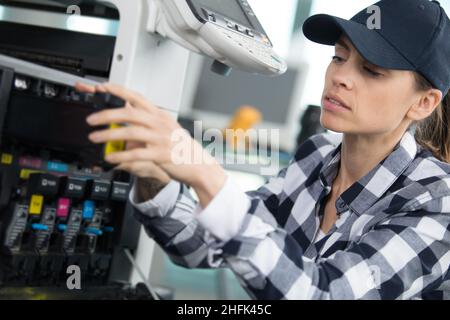 femme préparant une imprimante en magasin Banque D'Images