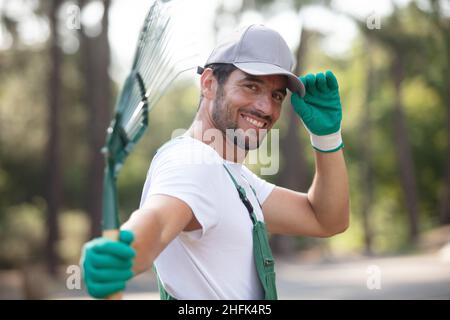 Homme de flou artistique le ratissage des feuilles au jardin Banque D'Images