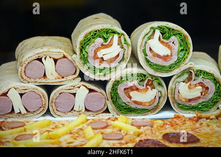 Petits pains de lips de Piadina présentés, avec salade, tomate et mozzarella Banque D'Images