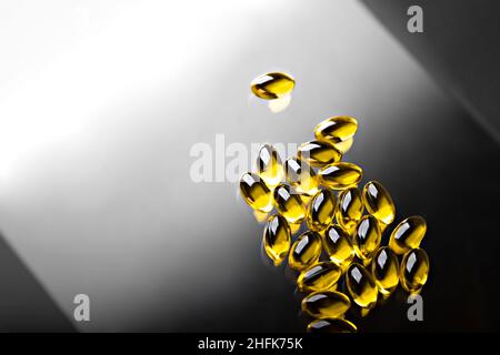Capsules transparentes à l'huile de poisson Omega 3 sur fond noir et blanc Banque D'Images