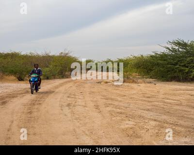 Senegal. Africa.- Feb, 2019: Motor on the road on the African steppe during dry season.  Trees of happiness, Senegal. Africa. Banque D'Images