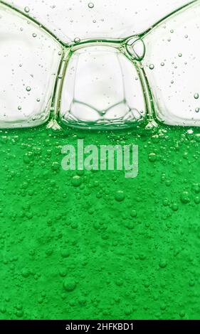 Bulles dans le shampooing vert translucide.Arrière-plan abstrait, gros plan Banque D'Images