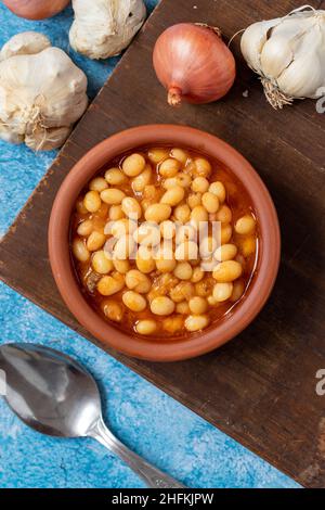 Ragoût de haricots turcs chauds sur fond bleu.Haricots Ispir cuits dans une casserole - Kuru Fasulye Banque D'Images