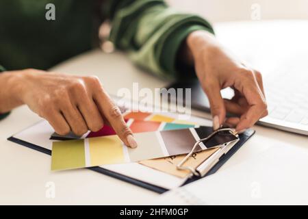 Gros plan sur les mains des femmes tenant et choisissant des palettes de couleurs intérieures Banque D'Images
