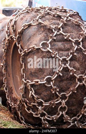 Le détail des roues et des pneus du véhicule agricole.Equipé de chaînes antidérapantes pour la conduite dans la boue. Banque D'Images