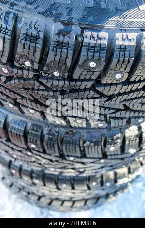 Le détail des nouveaux pneus d'hiver avec crampons pour une maîtrise précise de la conduite sur glace et neige sur chaussée glissante. Banque D'Images