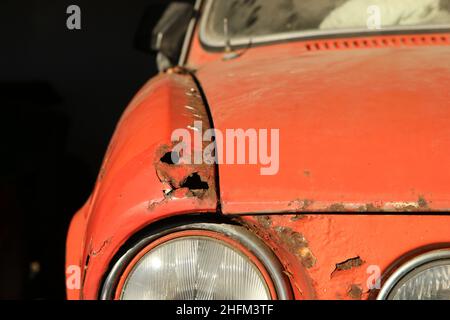 Le détail de la partie avant d'une voiture classique négligée.Le capot et l'aile en métal sont rouillés et doivent être rénovés. Banque D'Images