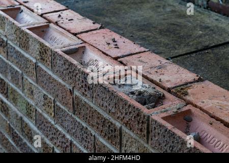 Un mur de jardin solide, double brique en cours de construction. Banque D'Images