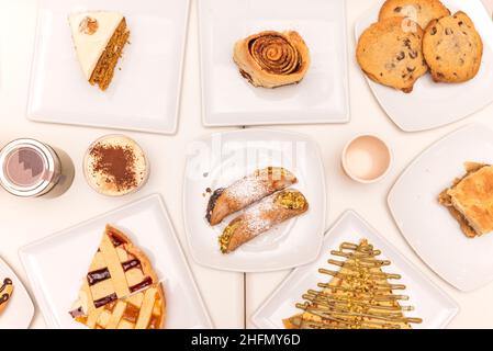 Vue de dessus image d'un ensemble de desserts, bonbons et gâteaux variés tels que cannoli, crêpes, biscuits, rouleau de citron et gâteau de carotte Banque D'Images