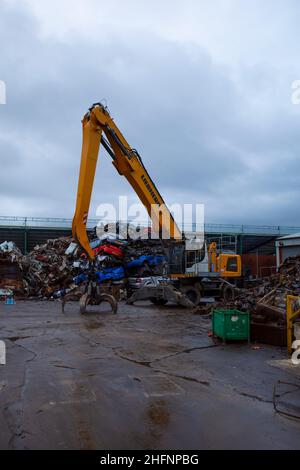 Un petit chantier de ferraille dans une zone industrielle du North Yorkshire manipulant principalement des wagons de ferraille avec une grue Liebherr LH40 Banque D'Images