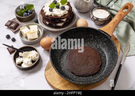 Petit déjeuner sain.Ingrédients pour la cuisson et crêpes délicieuses avec myrtilles et ricotta sur un plan d'examen en marbre. Banque D'Images